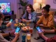 Engaging moment at https://3patiblueapp.com.pk/ where friends enjoy playing colorful card games together on smartphones in a cozy living room.