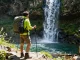 Pemandangan terjun4d yang menakjubkan dengan penggiat petualangan di tepi tebing.