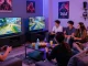 Friends enjoying a gaming session in a vibrant hit club atmosphere with cozy seating and colorful lighting